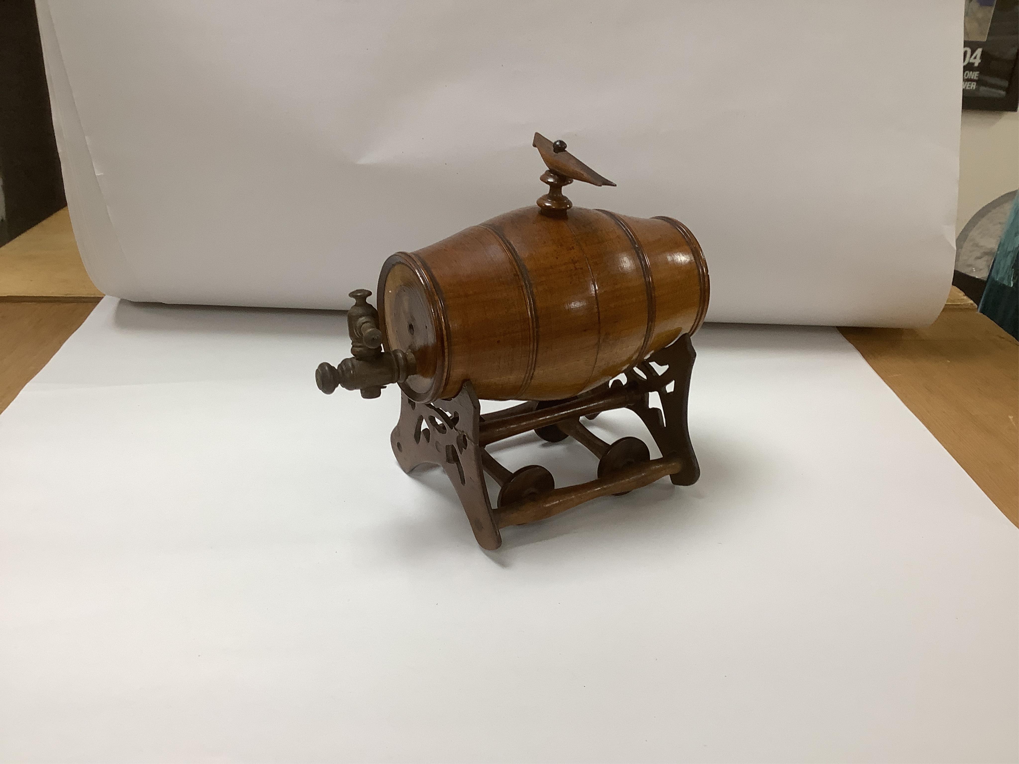 A group of treen to include a spirit barrel with turned wood spigot tap, on wheeled trolley, 17cm long, a pepper grinder, sand timer, etc. (6). Condition - fair